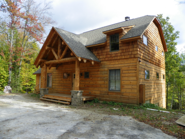 Custom rustic log truss and entryway and log siding by Adirondack LogWorks