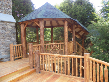 Custom rustic log gazebo with log railings, stairs, trusses, posts, and twig woodwork by Adirondack LogWorks