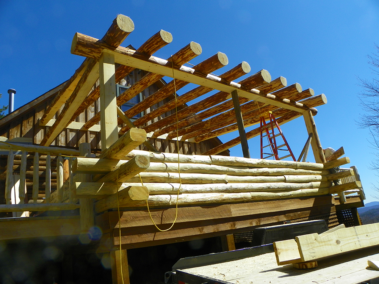 Custom rustic log truss woodwork on a log sunroom by Adirondack LogWorks