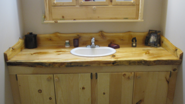 Custom rustic log vanity with live-edge counter top by Adirondack LogWorks