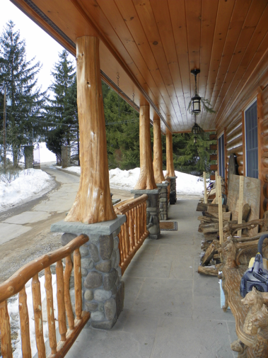 Custom rustic log entryway and log railings on a log home by Adirondack LogWorks