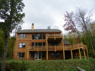 Custom rustic log railings, posts, and siding by Adirondack LogWorks