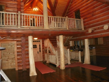 Custom rustic log posts, stairs, and railings at a log home by Adirondack LogWorks