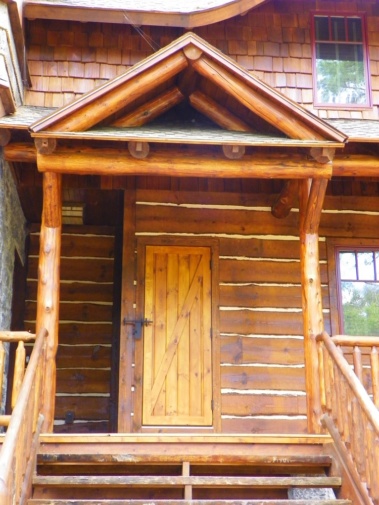 Custom rustic log truss, entryway, stairs, railings, and siding woodwork by Adirondack LogWorks
