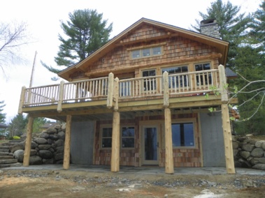 Custom rustic log entryway, posts, siding, and railings by Adirondack LogWorks