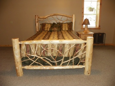 Custom rustic log bed with twig headboard and twig footboard by Adirondack LogWorks