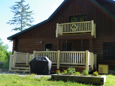 Custom rustic log stairs and railings with diamond twig inlay at a log home by Adirondack LogWorks