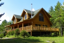 Custom rustic log railings at a log home by Adirondack LogWorks