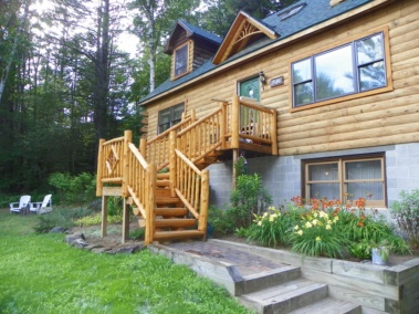 Custom log stairs and railings with diamond twig inlay at a log home by Adirondack LogWorks