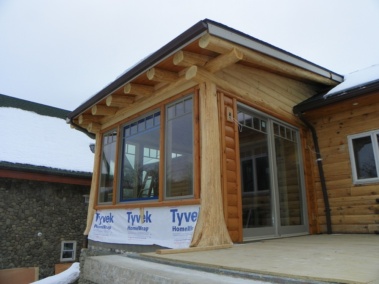 Custom log home breakfast nook with rustic flair posts and truss woodwork by Adirondack LogWorks