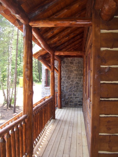 Custom log home truss, entryway, siding, and railing woodwork by Adirondack LogWorks