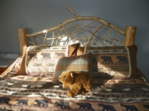 Custom rustic log bed with twig headboard by Adirondack LogWorks