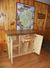 Custom rustic log cabinet with wood drawers and doors and live-edge woodwork and liquid glass top by Adirondack LogWorks