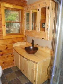 Custom rustic log vanity with live-edge woodwork and medicine cabinet furniture by Adirondack LogWorks