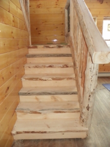 Custom rustic live-edge log stairs and railing woodwork by Adirondack LogWorks