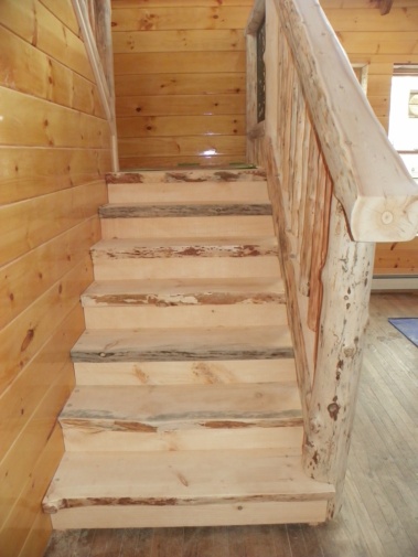 Custom rustic live-edge log stairs and railing woodwork by Adirondack LogWorks