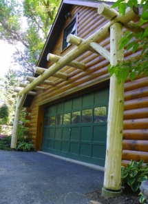 Custom rustic log pergola entryway to garage with log support posts by Adirondack LogWorks