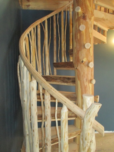 Custom rustic log spiral stairs and log railings by Adirondack LogWorks