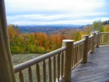 Custom rustic log railings and spindles on a log home in Vermont by Adirondack LogWorks